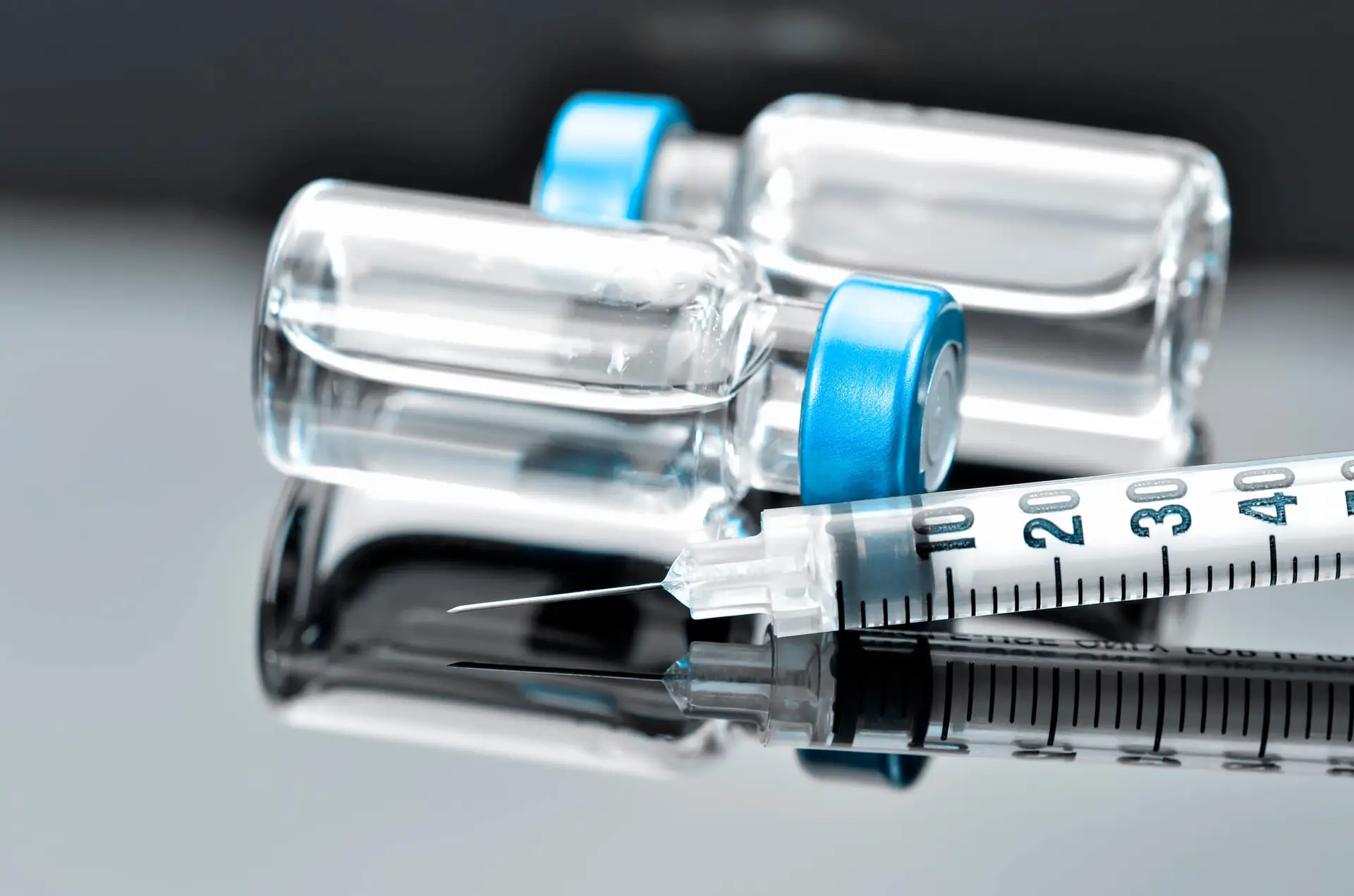 Syringe and vials with blue tops. Resolian Bioanalytics and Analytical Sciences.